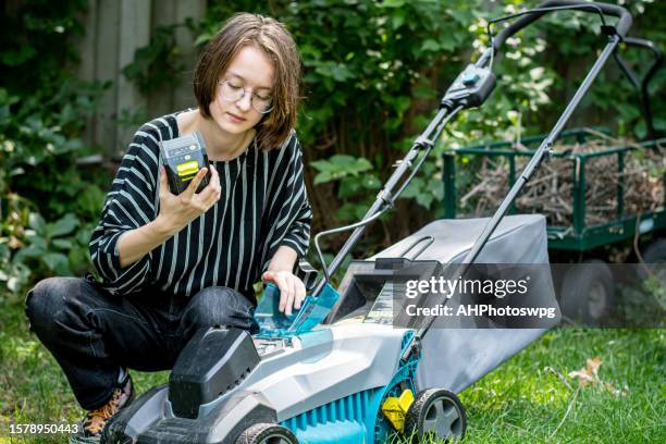 green innovation: gender nonconforming teen embraces eco-friendly lawn mowing - gräsklippare bildbanksfoton och bilder