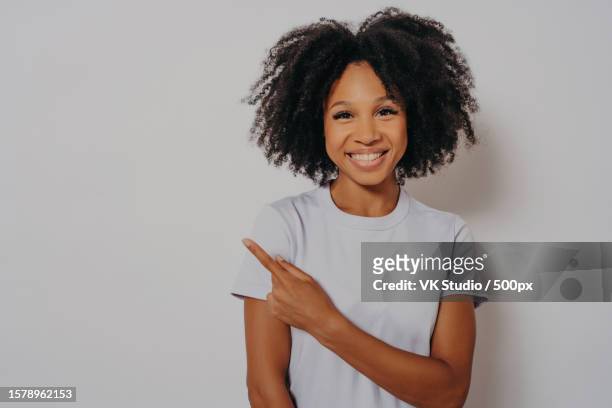 beautiful black woman cheerful with beaming smile on her face pointing with hand and finger up - editorial template stock pictures, royalty-free photos & images