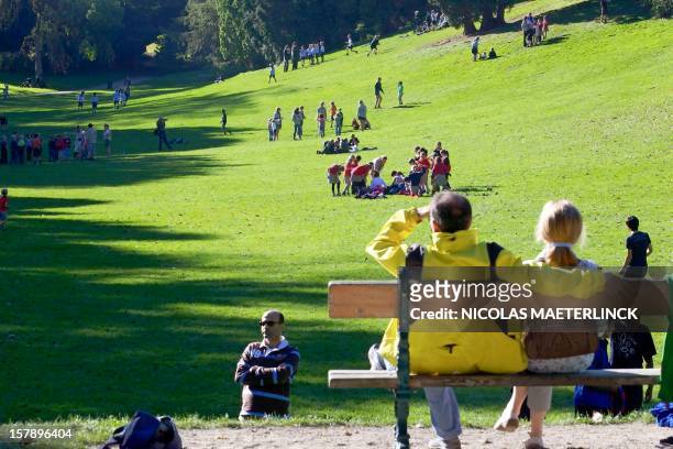 People as they enjoy warm weather at Woluwe Park Tennis Chalet, in Sint-Pieters-Woluwe / Woluwe-Saint-Pierre, in Brussels, on October 10, 2010. AFP...