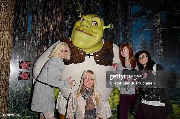 Pussycat Doll Kimberly Wyatt poses with fans next to a wax figure of Shrek at Madame Tussauds on December 7, 2012 in London, England.