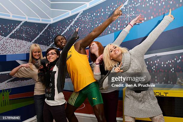 Pussycat Doll Kimberly Wyatt poses with fans next to a wax figure of Usain Bolt at Madame Tussauds on December 7, 2012 in London, England.