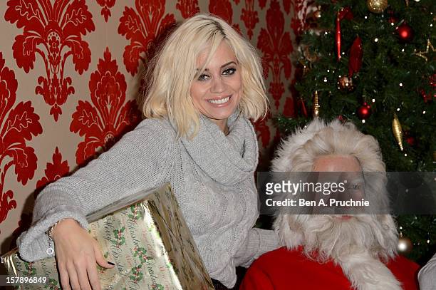 Pussycat Doll Kimberly Wyatt poses next to a wax figure of Santa Claus at Madame Tussauds on December 7, 2012 in London, England.