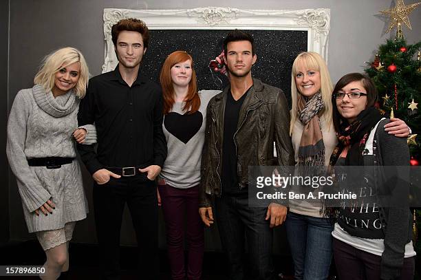 Pussycat Doll Kimberly Wyatt poses with fans next to wax figures of Robert Pattinson and Taylor Lautner at Madame Tussauds on December 7, 2012 in...