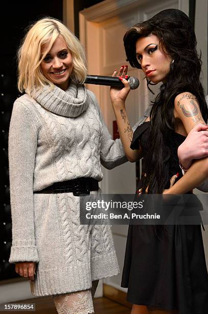 Pussycat Doll Kimberly Wyatt poses next to a wax figure of Amy Winehouse at Madame Tussauds on December 7, 2012 in London, England.