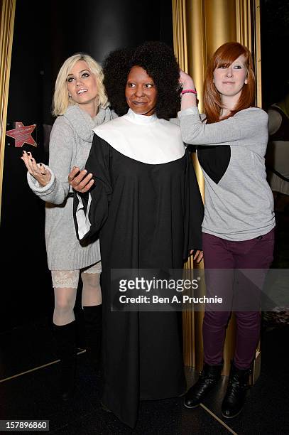 Pussycat Doll Kimberly Wyatt poses with a fan next to a wax figure of Whoopi Goldberg at Madame Tussauds on December 7, 2012 in London, England.