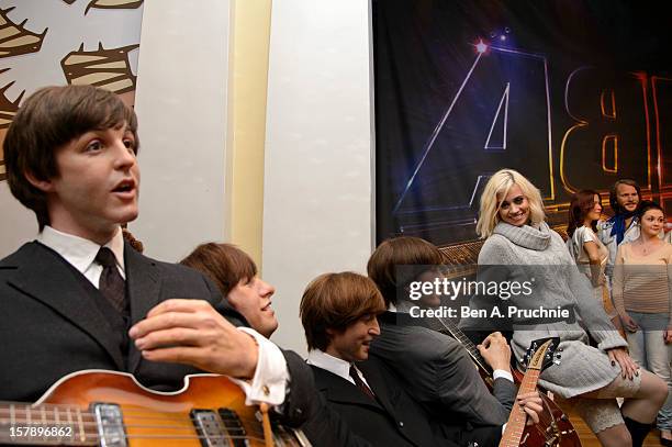 Pussycat Doll Kimberly Wyatt poses next to wax figures of the Beatles at Madame Tussauds on December 7, 2012 in London, England.