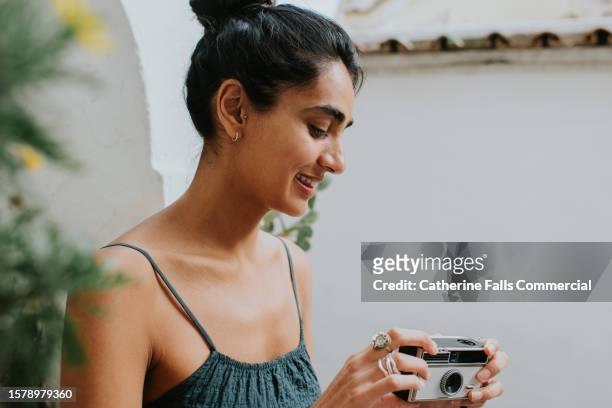 side profile of a beautiful young indian woman with her hair pulled back in to a high bun - reporterstil stock-fotos und bilder