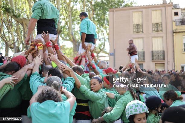 "Castellers" attend a "Castells" performance during the feria of Millas, southern France on August 5, 2023. The men below, the women above, the...