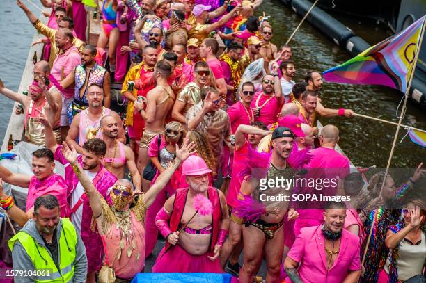 View of a boat full of mostly men wearing pink clothes during the event. The Canal Parade starts around noon and takes all afternoon. Around 80 boats...
