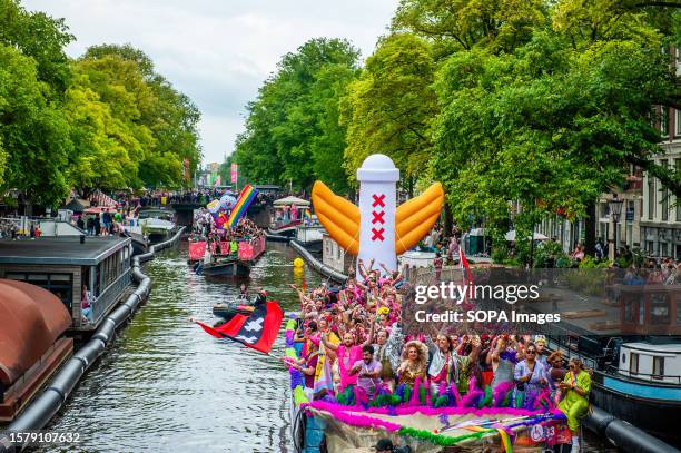 People from the council of Amsterdam are seen partying on one of the boats during the event. The Canal Parade starts around noon and takes all...