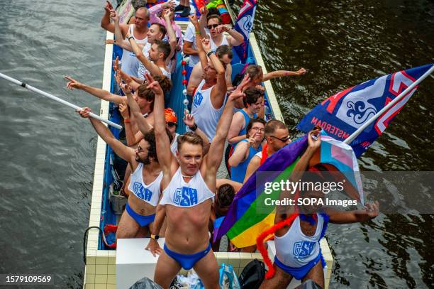 Gay gymnasts are seen dancing on a small boat during the event. The Canal Parade starts around noon and takes all afternoon. Around 80 boats of...