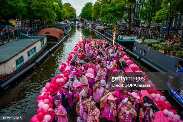 Boat is seen full of people wearing pink clothes during the event. The Canal Parade starts around noon and takes all afternoon. Around 80 boats of...