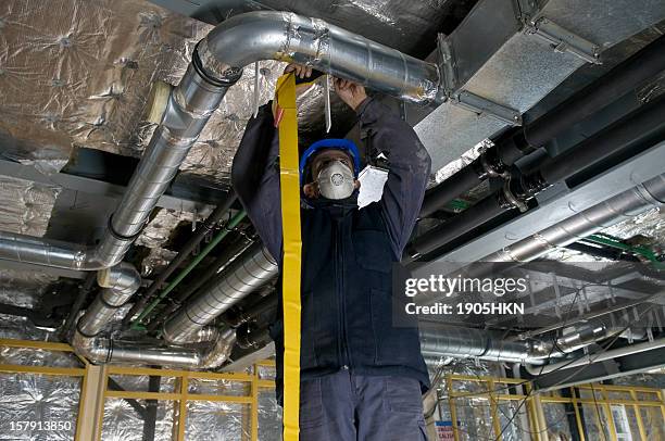 worker wrapping an hvac air duct with foil tape - pipes and ventilation stock pictures, royalty-free photos & images