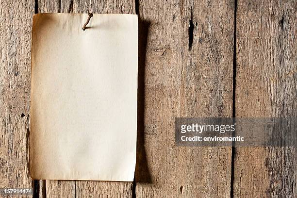 old paper nailed to a weathered wooden board. - pinning stock pictures, royalty-free photos & images