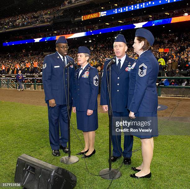 Members of the Michigan National Guard and of the signing group the110th Airlift Wing Knights in Blue sing God Bless American in the seventh inning...