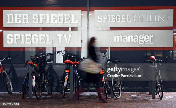 Woman walks past the signs of the different divisions of the editorial offices of German news weekly Der Spiegel on December 7, 2012 in Hamburg,...