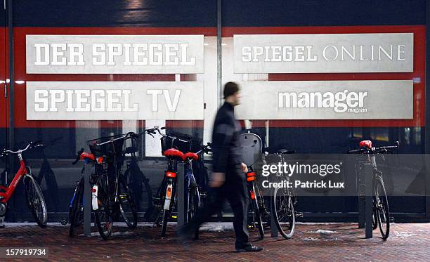 Man walks past the signs of the different divisions of the editorial offices of German news weekly Der Spiegel on December 7, 2012 in Hamburg,...