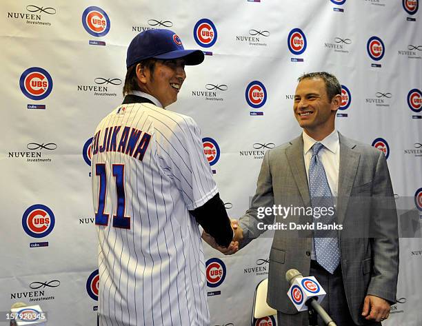 Chicago Cubs new pitcher Kyuji Fujikawa shakes hands with Chicago Cubs general manager Jed Hoyer December 7, 2012 at Wrigley Field in Chicago,...