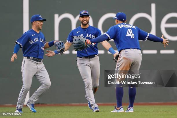 Kevin Kiermaier of the Toronto Blue Jays, center, celebrates with George Springer and Whit Merrifield after Kiermaier made a catch and threw to...