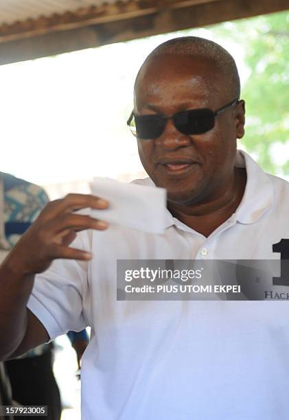 Ghana's ruling National Democratic Congress president and presidential candidate John Dramani Mahama kisses his ballot prior to casting his vote at...
