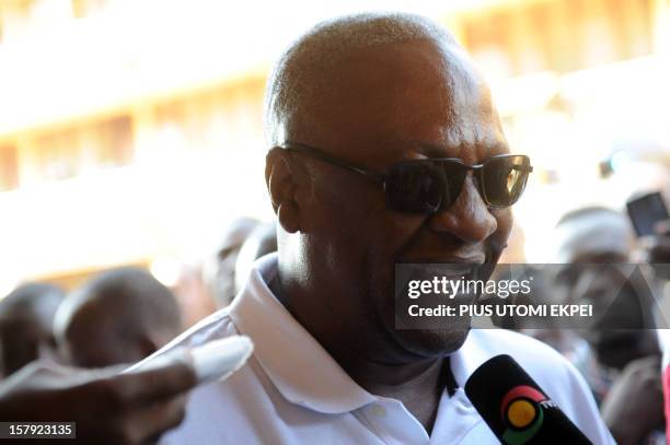 Ghana's ruling National Democratic Congress president and presidential candidate John Dramani Mahama smiles while talking to the press after casting...