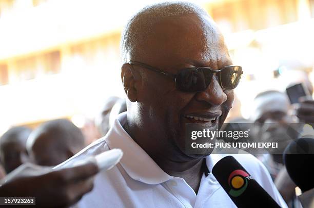 Ghana's ruling National Democratic Congress president and presidential candidate John Dramani Mahama smiles while talking to the press after casting...