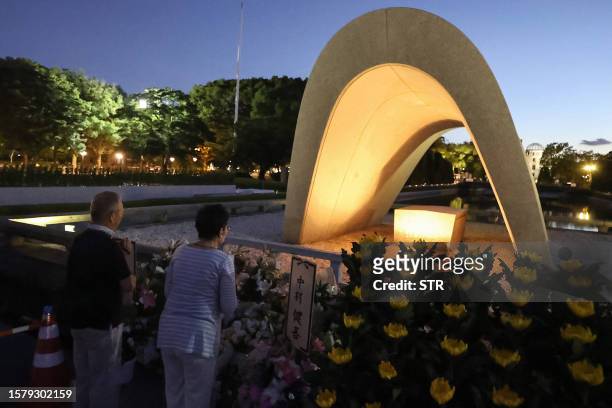 People visit and say prayers at sunrise at the cenotaph for the atomic bomb victims at the Peace Memorial Park in Hiroshima on August 6 to mark the...