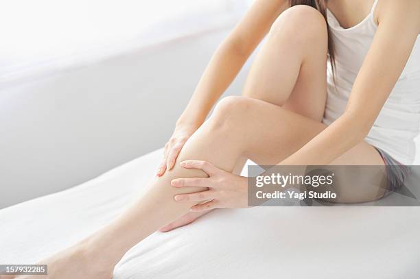 woman massaging legs - 足 ストックフォトと画像