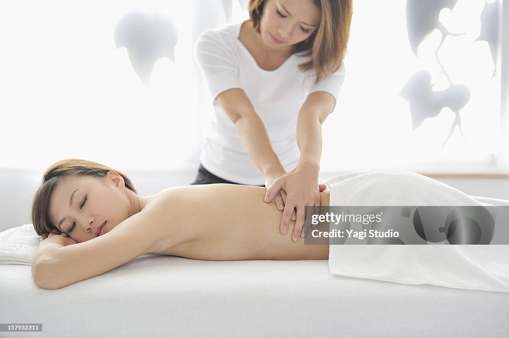 Young woman receiving massage, eyes closed
