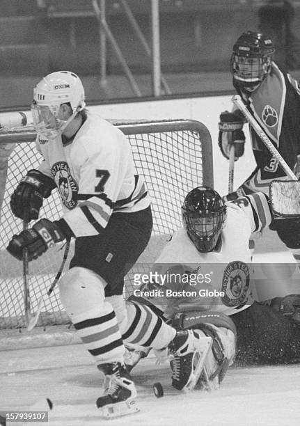 Northeastern University's goalie Mike Veisor, #35, deflects a shot as team mate Arttu Kayhko, #7, left, defends in another direction. At right is...