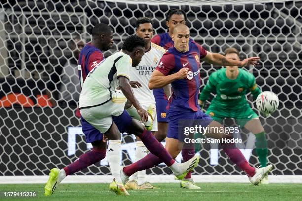 Oriol Romeu of FC Barcelona deflects a shot from Vini Jr. #7 of Real Madrid during the first half of the pre-season friendly match at AT&T Stadium on...