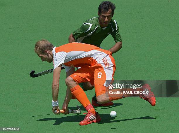 Rasid Mehmood of Pakistan makes a pass through Bill Bakker of The Netherlands during their semi final match at the Men's Hockey Champions Trophy in...