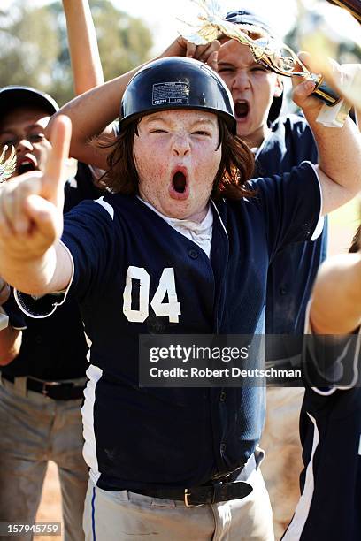 a little league player celebrates with trophy. - camisa de beisebol - fotografias e filmes do acervo