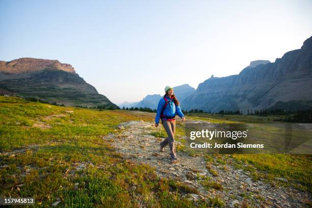 a female backpacking in the mountains. - glacier national park montana stock pictures, royalty-free photos & images