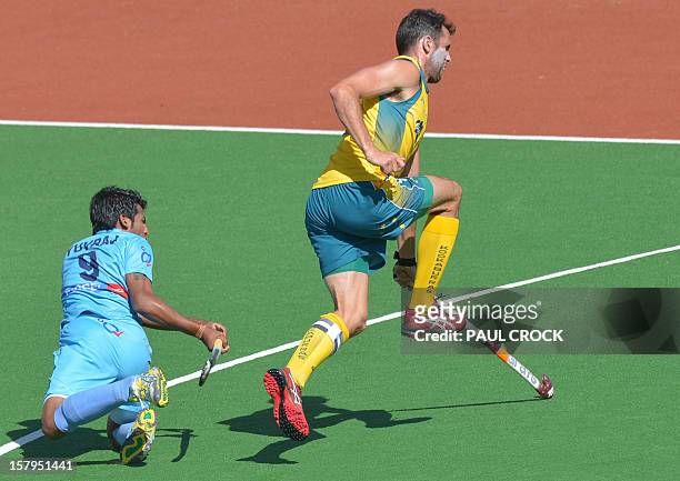 Mark Knowles of Australia leaps as Yuvraj Walmiki of India has a shot at goal during the second semifinal at the men's Hockey Champions Trophy...