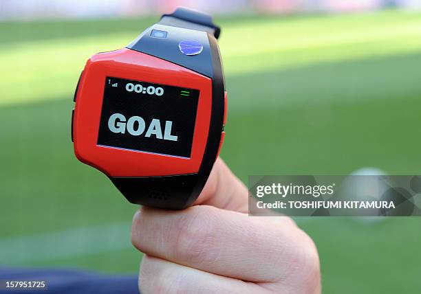 Officer displays a watch displaying "goal" during a demonstration of new goal-line technology by Hawk-Eye Innovations at Toyota Stadium in Toyota,...