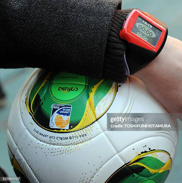 Officer displays a watch displaying "goal" and a ball during a demonstration of new goal-line technology by Hawk-Eye Innovations at Toyota Stadium in...