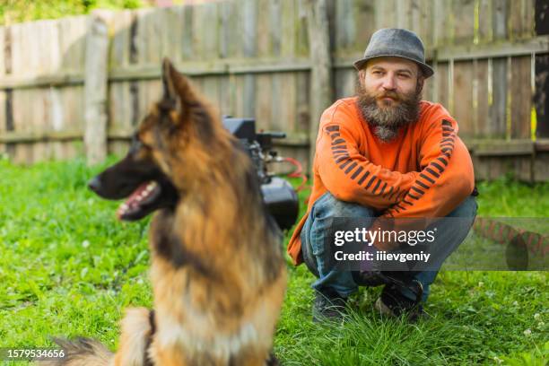 beard man with german shepherd in the back yard - german shepherd portrait stock pictures, royalty-free photos & images