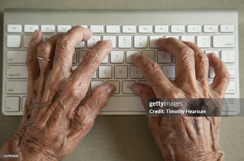 Detail - elderly woman typing on wireless keyboard