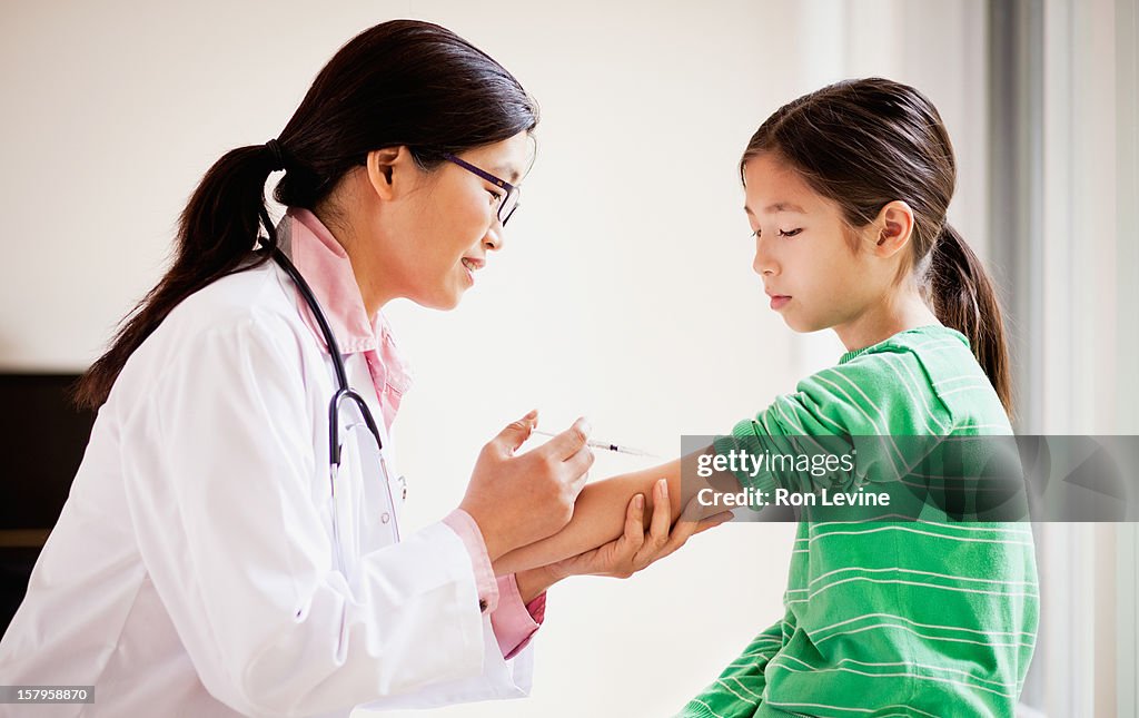 Doctor about to give vaccination to young patient