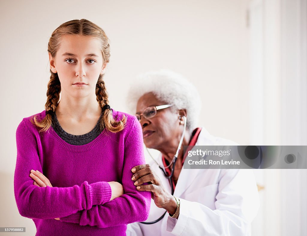 Senior doctor listens to young patient's lungs