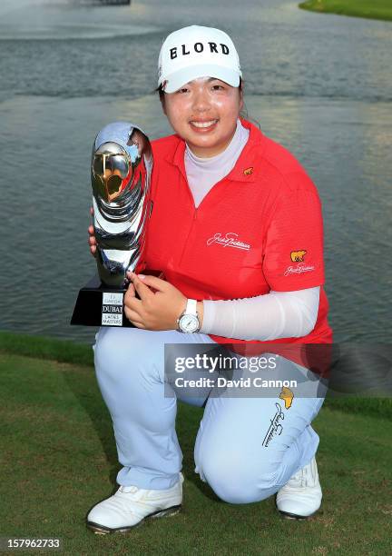 Shanshan Feng of China holds the Dubai Ladies Masters trophy after the final round of the 2012 Omega Dubai Ladies Masters on the Majilis Course at...