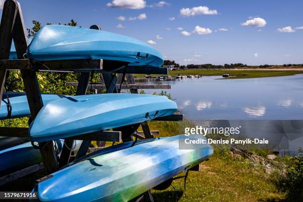 stacked canoes by pond - panyik-dale stock pictures, royalty-free photos & images