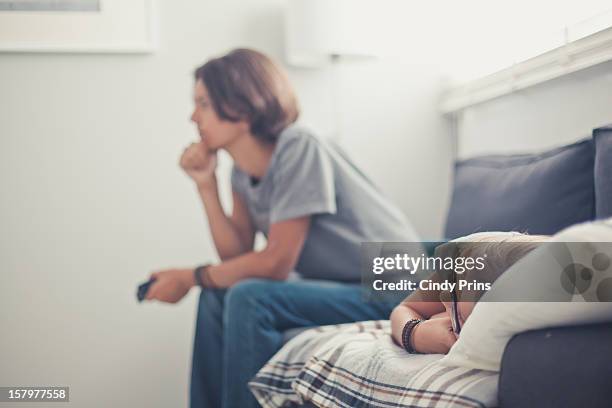 two boys relaxing on the couch, watching tv - boys relaxing stock pictures, royalty-free photos & images