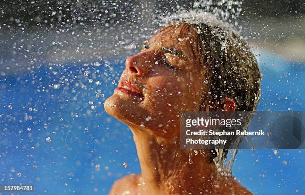teenager taking a shower in the sun - stephan rebernik stock-fotos und bilder