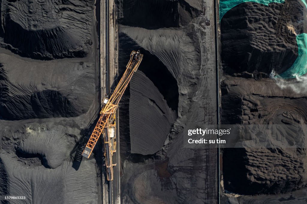 The factory land full of coal is mechanically operating and transported