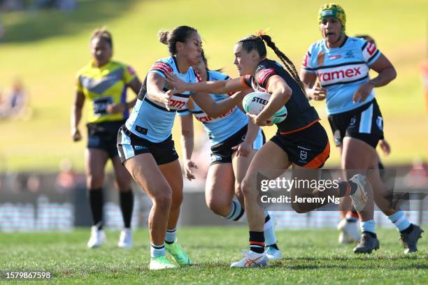 Jakiya Whitfield of the Tigers fends off Kiana Takairangi of the Sharks during the round two NRLW match between Wests Tigers and Cronulla Sharks at...