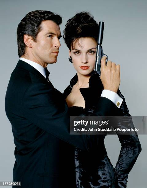 Irish actor Pierce Brosnan as James Bond, with his 'GoldenEye' co-star Famke Janssen, 1995. He is holding a Walther PPK with a silencer.