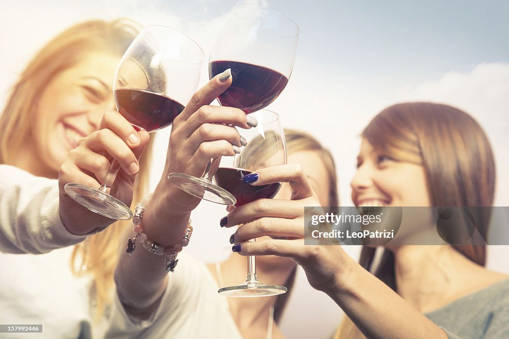 Mädchen Anstoßen mit Wein im Freien während der happy hour.