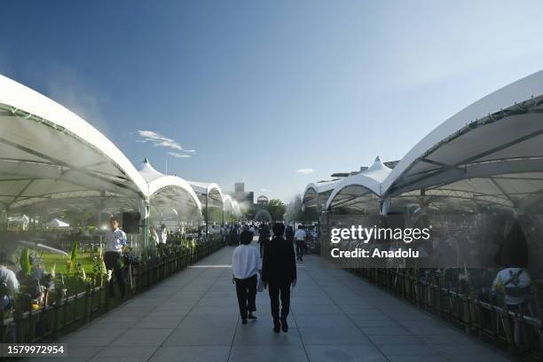 People arrive at the Peace Memorial Park where a ceremony is held to pay tribute for the atomic bomb victims in Hiroshima, Japan, on August 06, 2023....